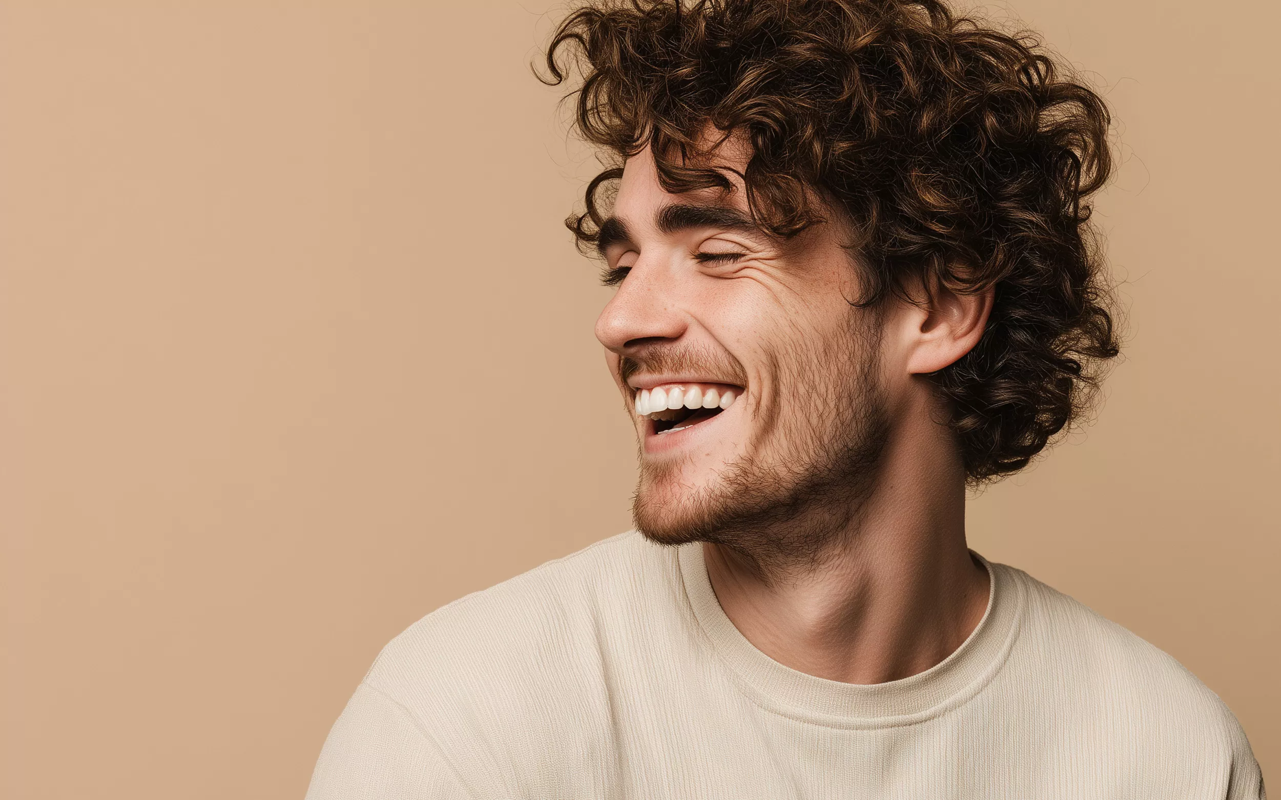 Ragazzo sorridente su sfondo beige